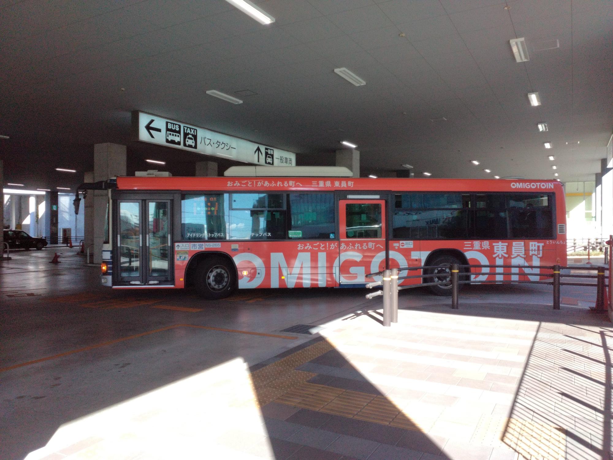 赤を基調としたデザインでOMIGOTO(おみごと)の文字をボディーへ印字した東員町をPRするラッピングバス