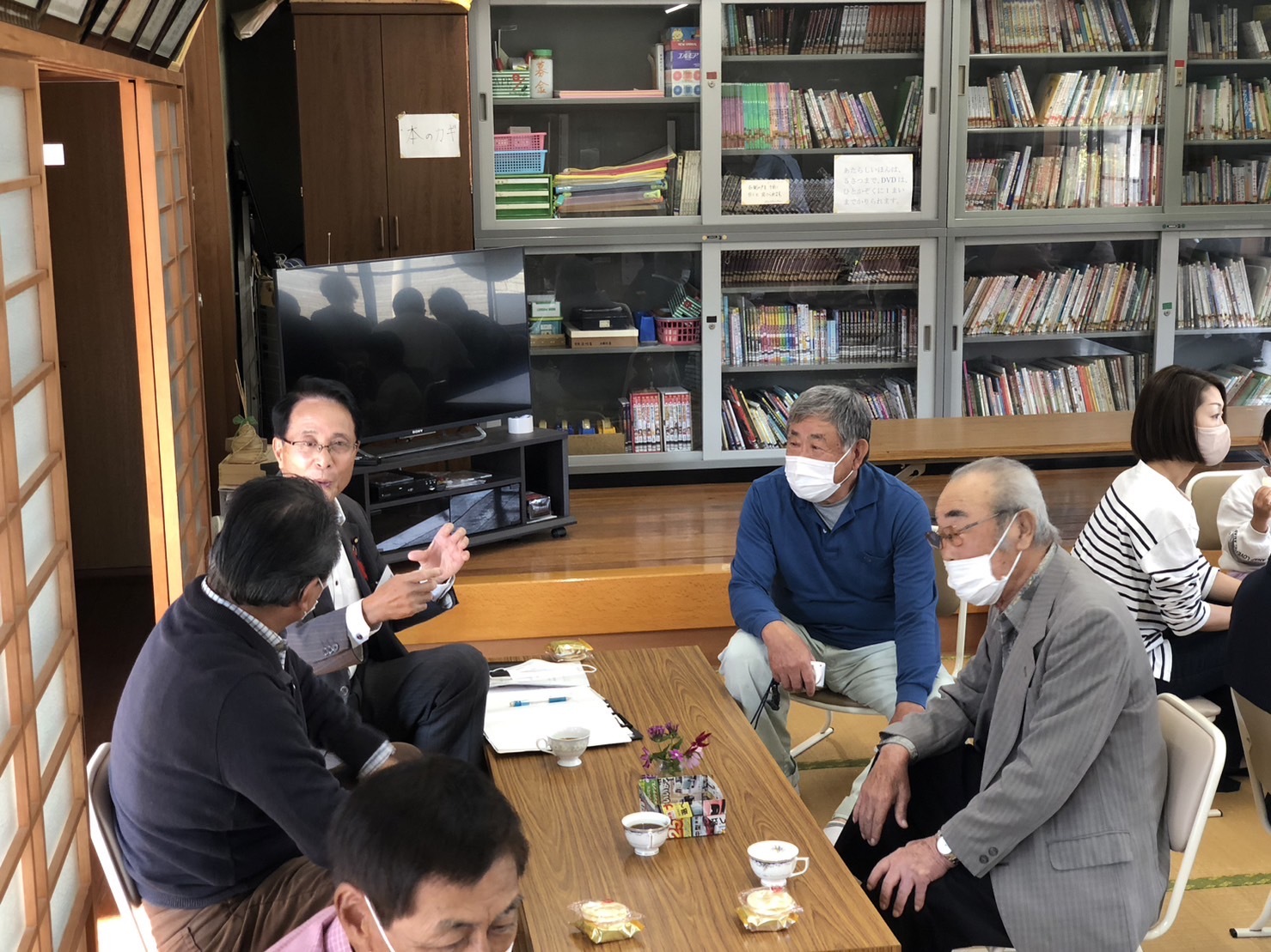 同じテーブルの町民に説明をする議員の写真