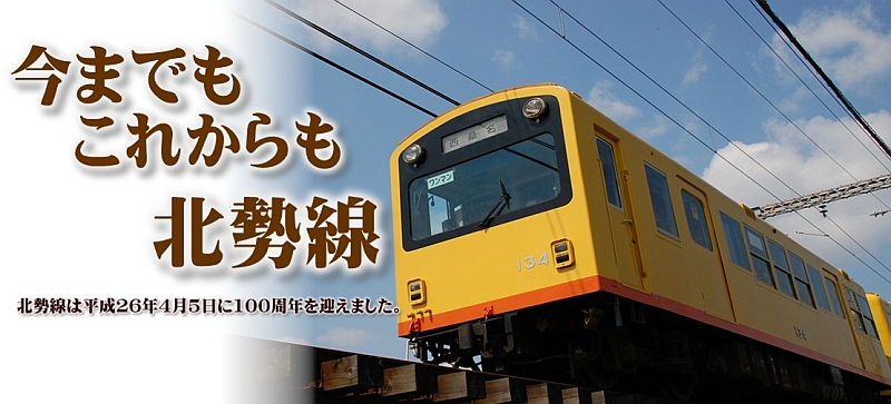 今までもこれからも北勢線 北勢線は平成26年4月5日に100周年を迎えました。（陸橋を渡る黄色にオレンジのラインの列車の写真）