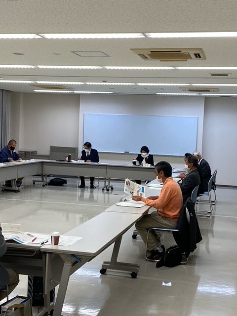 机に向かって資料に目を通す人たちの写真