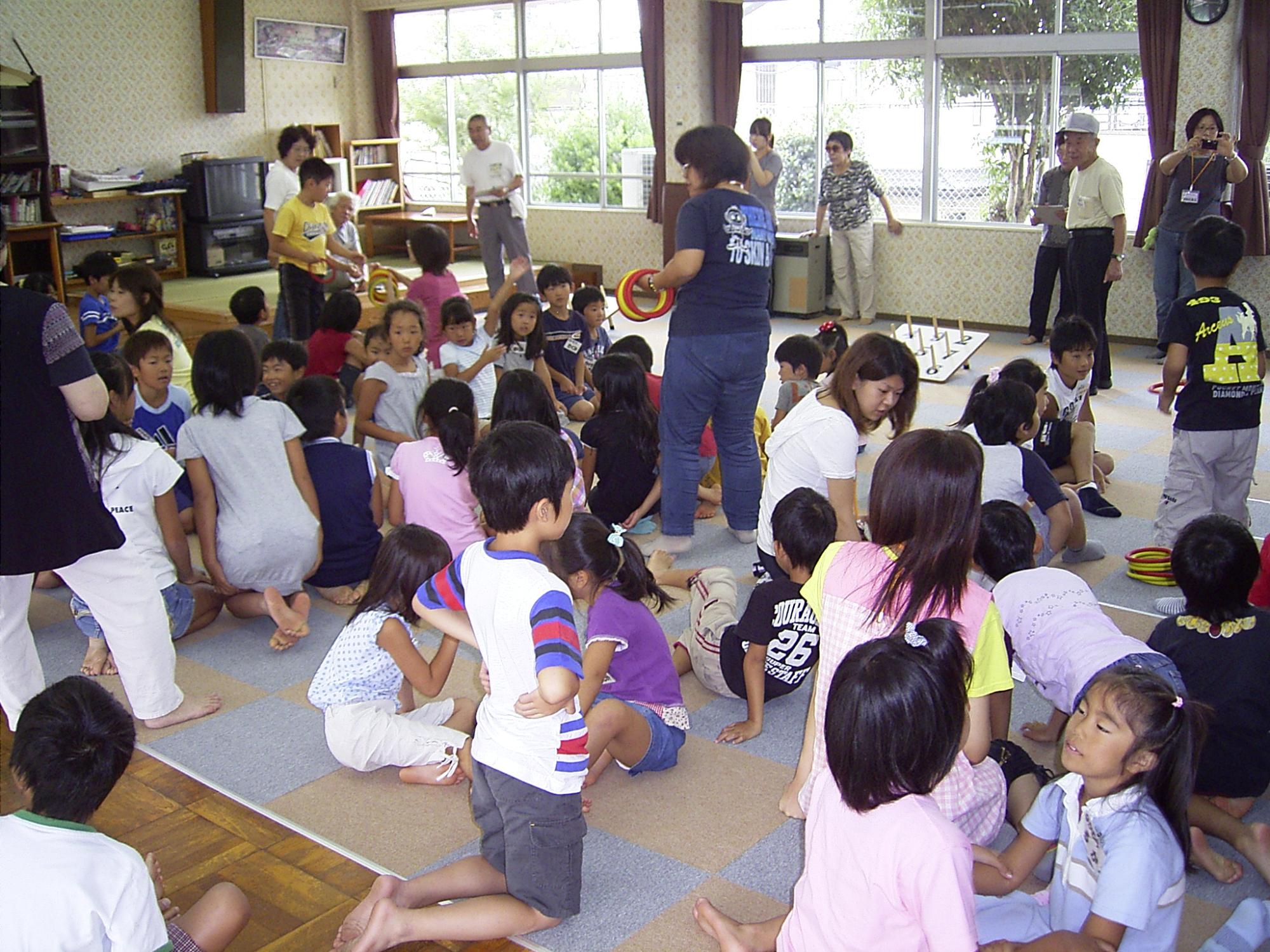 投げ輪をする子供たちと見守る大人たちの写真