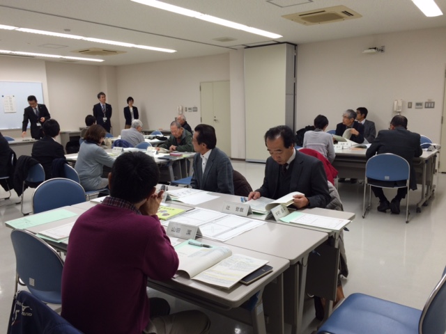映像を見せながら話をする人と資料を見ながら聴く人たちの写真