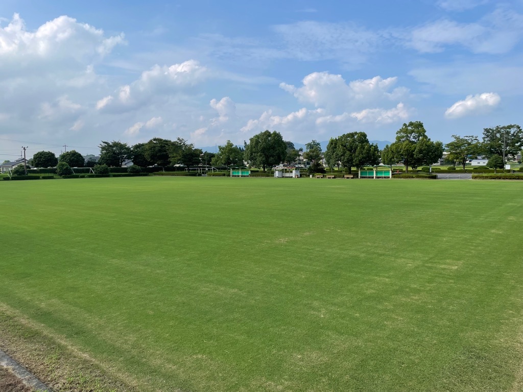 芝生と青空と木々が写る東員町スポーツ公園陸上競技場多目的グラウンド