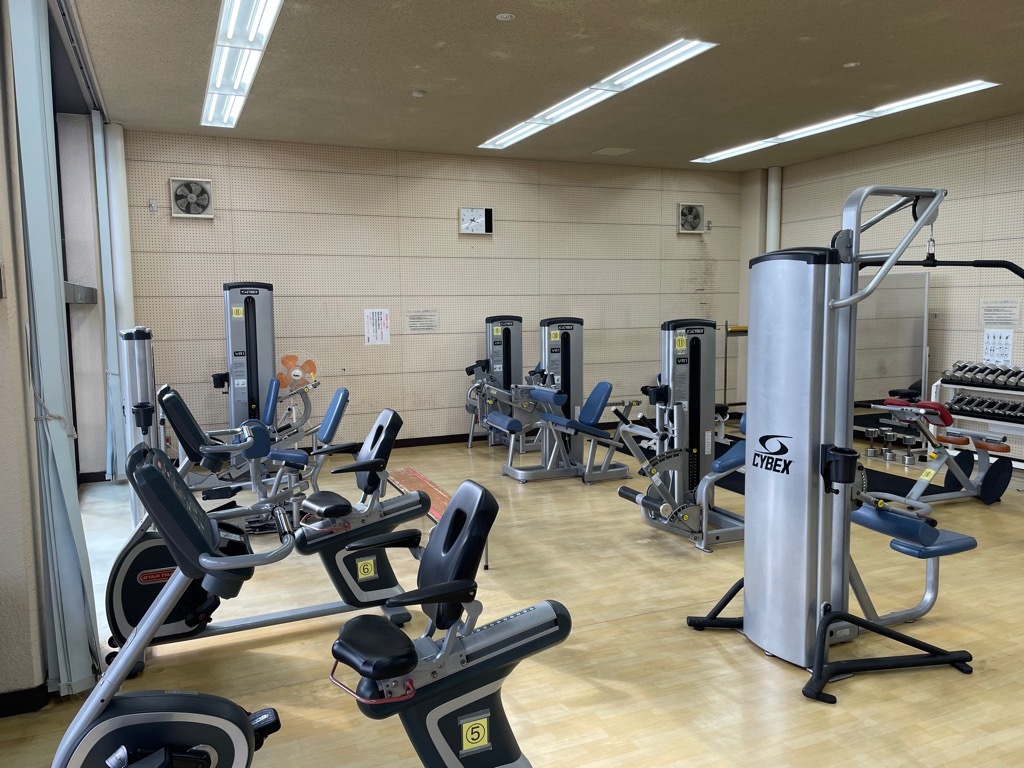 エアロバイクや重量挙げの器具が写っている東員町体育館のトレーニングルームの写真