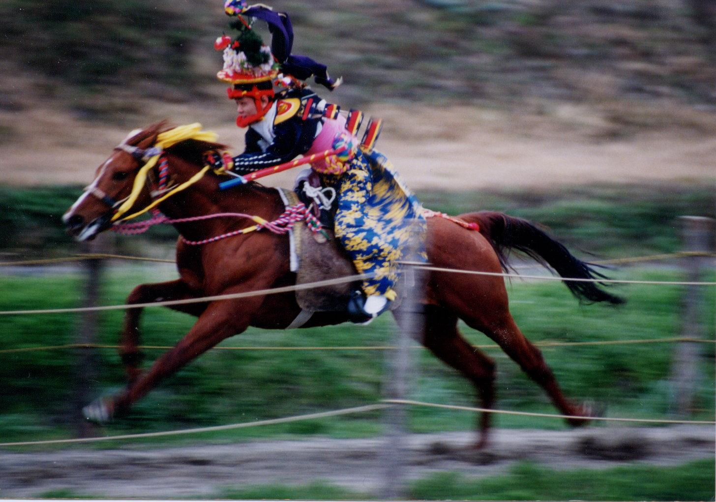 上げ馬神事で馬に乗って駆けている写真