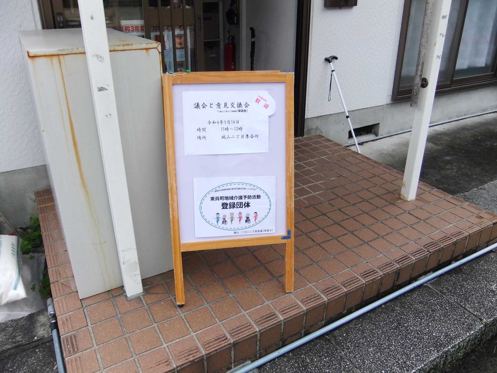 議員と意見交換会と書かれた立て看板が城山二丁目楽遊会正面玄関にある写真